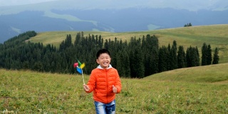 一个亚洲男孩在草原上玩风车