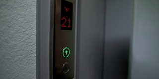 手指按电梯按钮到上层，电子液晶显示，特写