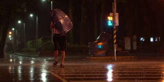 台风台湾期间，行人撑着雨伞挣扎着穿过街道