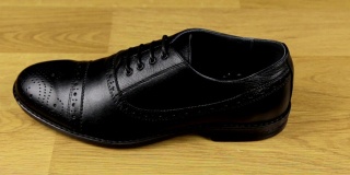 优雅的男式鞋带鞋立在木地板上。滑动条。