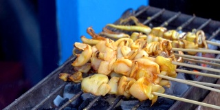 在食品市场的烤架上烤鱿鱼是泰国的街头小吃