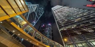 时间流逝的高层写字楼，摩天大楼，建筑在金融区。智慧城市为商业和科技的概念背景，在香港市中心的夜晚