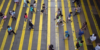 鸟瞰图的人群走在街道上斑马线或人行横道。商业交通道路在繁忙的城市。香港市区。