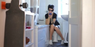 女孩坐在厕所里用手机应用