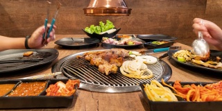 时间流逝:亚洲人在韩国餐厅烧烤。食品的概念