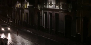 黑暗的街道，很少有路灯，在漆黑的夜晚，人们在大雨中奔跑
