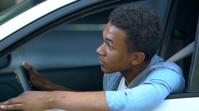紧张的非洲裔美国少年在车里被困在交通堵塞，开车