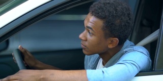 紧张的非洲裔美国少年在车里被困在交通堵塞，开车