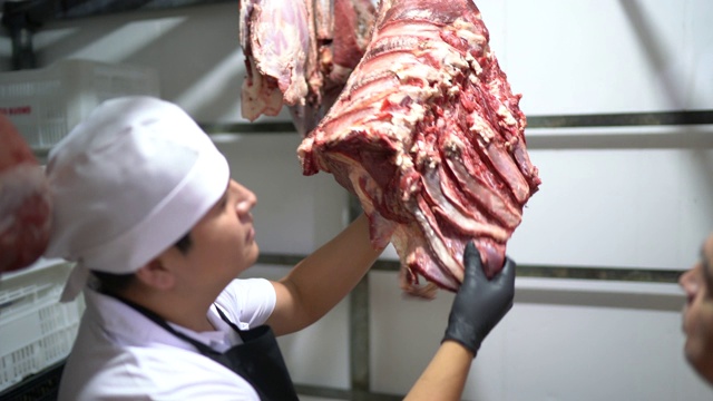 屠夫在肉柜里分析肉