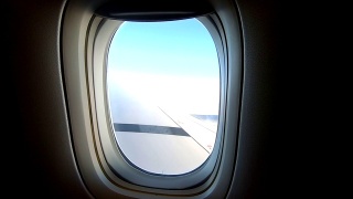 缩小镜头从天空的窗口飞机机翼。视频素材模板下载
