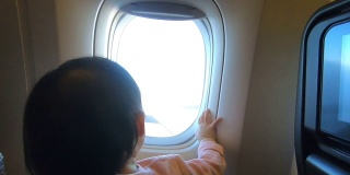 缩小镜头飞机机翼在天空与孩子的手在窗口。