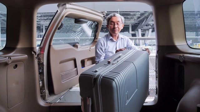 亚洲资深男子装载行李到汽车公路旅行。交通，旅行，旅程，人，全球，生活方式，假期，公路旅行，退休概念。在机场