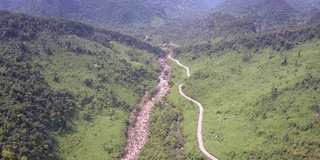 狭窄的柏油路沿着浅浅的山河蜿蜒而行