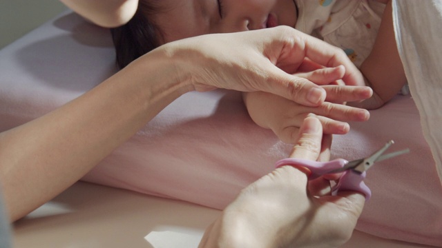 这是母亲在家里用指甲钳剪孩子的指甲的特写。婴儿身体护理概念。特写镜头前视图