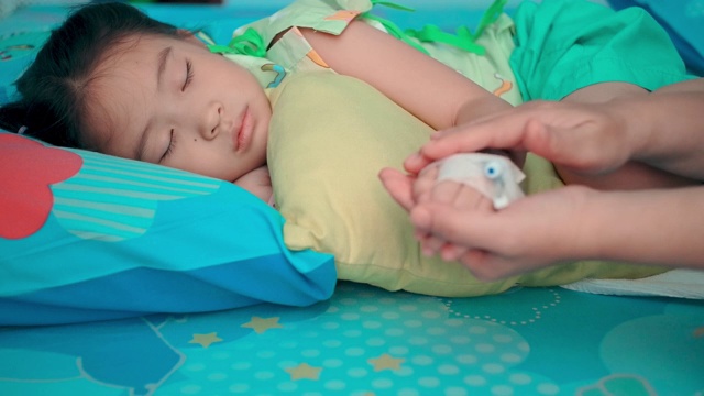 SLO MO生病的孩子在医院里睡觉，用手打点滴
