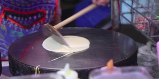 在泰国街头市场做薄饼。可丽饼配巧克力酱和碎坚果是一道美味的甜点