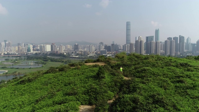 中国深圳旁边的香港，女超级马拉松运动员在山上跑步的鸟瞰图