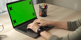 俯视图男性的手工作在笔记本电脑与绿色屏幕