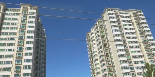 特写:阳光明媚的日子里，北京街道上高楼林立的公寓楼。