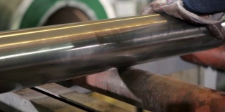 工业锯床切割材料棒。带锯机用冷却液切割原材料金属棒。