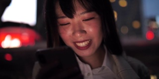 迷人的亚洲年轻女子在工作之余使用手机