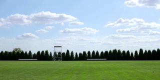 一张足球场的快照，有新修剪的草地和美丽的云彩