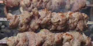 熏烤肉架上烤腌肉。特写新鲜肉串在烧烤架上