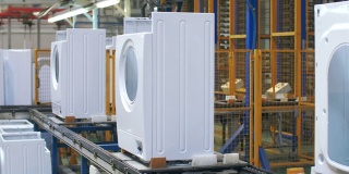 白色洗衣机机体在工业工厂的生产输送机上移动
