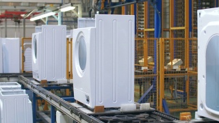 白色洗衣机机体在工业工厂的生产输送机上移动视频素材模板下载