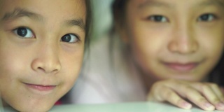 两个亚洲小女孩做的和平手势