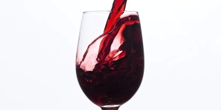 葡萄酒。红酒倒入酒杯中，背景为白色。中心组成。