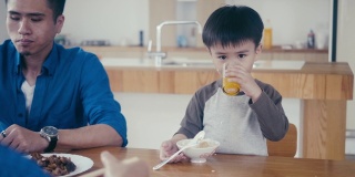 亚洲小男孩吃米饭和喝果汁
