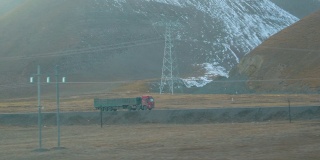 慢镜头:从移动的火车上看到一辆卡车在西藏运输货物。