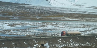 慢镜头:卡车沿着空旷的道路行驶，驶过喜马拉雅山脉。