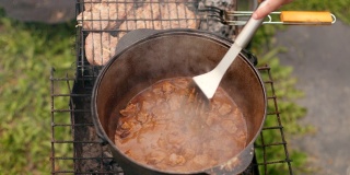 在大铁锅里准备菜，用红洋葱和肉等组成