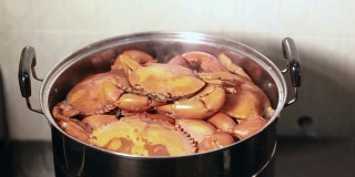 手开盖锅中蒸螃蟹。活螃蟹在锅中蒸。上海大闸蟹，中国美食。清蒸蟹，中国海鲜摊位。
