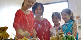 快乐的亚洲家庭在中国新年庆祝活动中祈祷繁荣