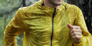 一个健壮、肌肉发达的年轻人穿着运动服在雨中在街上慢跑