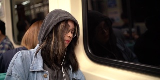 一个年轻的亚洲女人睡在地铁里