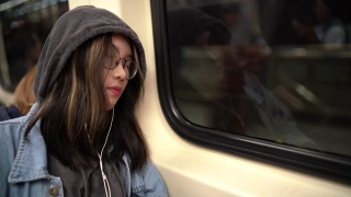 一个年轻的亚洲女人睡在地铁里视频素材模板下载