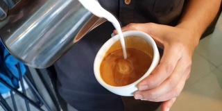 拿铁艺术，咖啡师把牛奶倒在咖啡上。