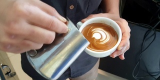 拿铁艺术，咖啡师把牛奶倒在咖啡上。