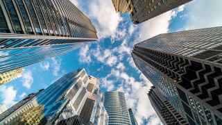 4K时间流逝芝加哥市中心摩天大楼的上升角度与高楼之间的云反射，伊利诺伊州，美国，商业和透视概念视频素材模板下载