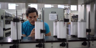 在橡胶带生产线上计数的拉丁美洲年轻工人