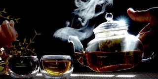 慢镜头，热腾腾的菊花茶从一个玻璃罐里倒进一杯热气腾腾的白烟。