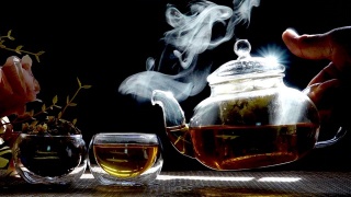 慢镜头，热腾腾的菊花茶从一个玻璃罐里倒进一杯热气腾腾的白烟。视频素材模板下载