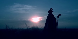 一个穿着女巫服装的女人在山上扫把夜