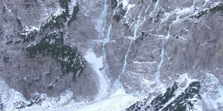AERIAL:冰冻的河流从斯洛文尼亚一座雪山的悬崖上倾泻而下。