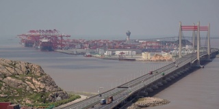 工业港口鸟瞰图，桥上有货船和集装箱卡车