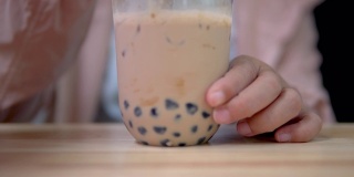 用塑料吸管在桌上搅拌台湾奶茶。